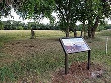 a plaque in front of a field